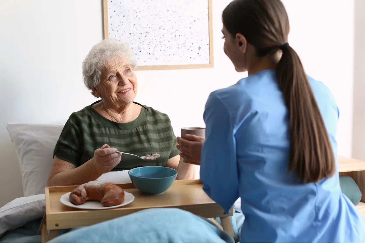 Caregiver serving a warm meal to senior resident